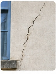 Fissure verticale visible sur une façade près d’une baie